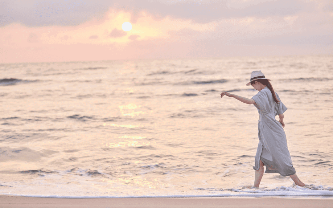 Woman walking along Wellington beach at sunrise — symbolising recovery after pelvic organ prolapse physiotherapy.