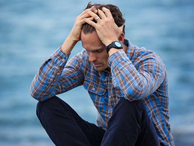 Man sitting with head in hands — chronic pelvic pain in men Wellington